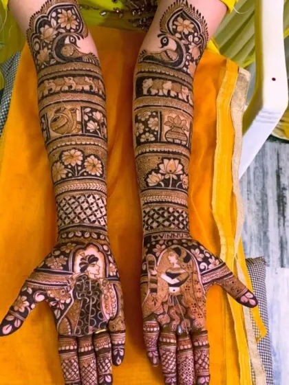 This elegant design features portraits of the bride and groom on the palms, with peacocks and elephants adorning the arms, creating a look of traditional grandeur.