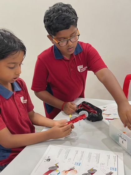 Teamwork in action at Vidyashilp Academy as two students collaborate on building a LEGO model.