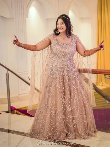 A joyful, candid shot of the bride dancing and smiling on the stairs at her engagement party.