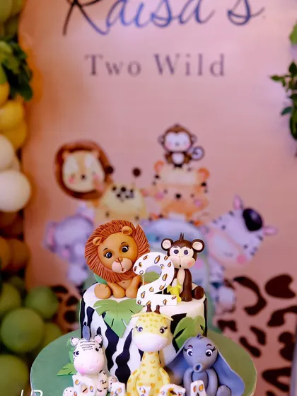 The birthday cake for the "Two Wild" party was a work of art, featuring fondant animals like a lion, monkey, and giraffe, perfectly matching the jungle theme.
