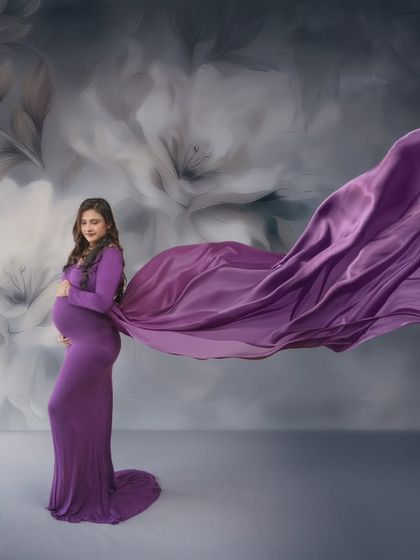 Radiant mumma, majestic vibes. This stunning solo shot captures the essence of motherhood's beauty with a flowing purple gown and a dramatic wind-swept effect.