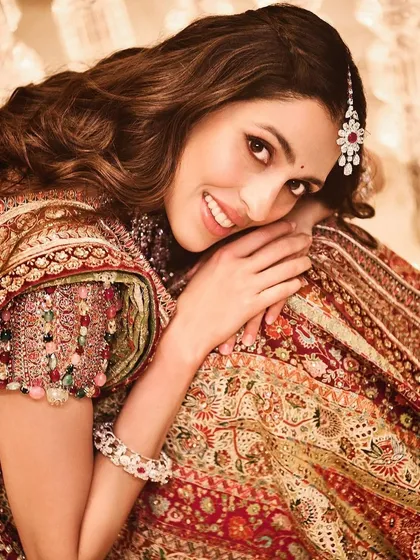 A close-up of the beautiful details on this Tarun Tahiliani lehenga, complete with a maang tikka. This look is all about celebrating tradition with a smile.