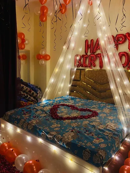 A side angle of the birthday decor, highlighting the soft glow from the lights on the bed frame and canopy.
