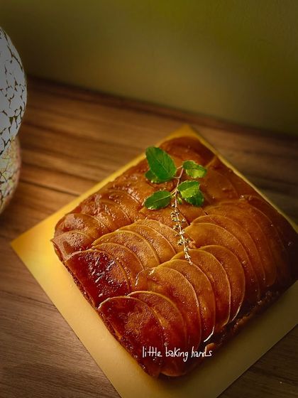 The stunning upside-down jaggery caramelised spiced pear cake, garnished with a sprig of mint.