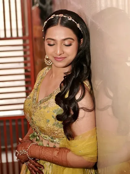 The glory of Dr. Priyanka's Haldi look. We created soft shimmery eyelids with a hint of smoked purple liner, muted lips, and super glowy skin.