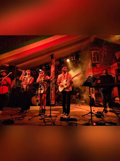 The band on stage under the warm red lights. We love the atmosphere of an intimate club show where we can feel the energy of the crowd up close.