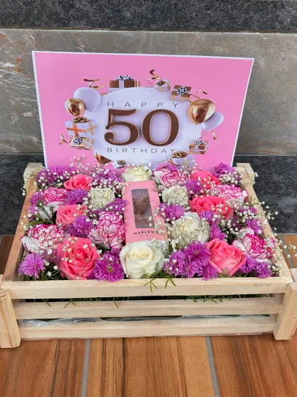 A stunning floral crate designed for a fabulous 50th birthday. This arrangement combines fresh, vibrant flowers with a personalized touch, making it the perfect centerpiece for a milestone celebration.