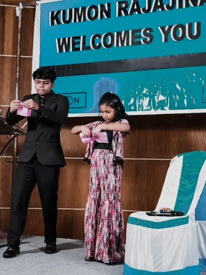 Audience participation is key to my family shows. Here, I've invited a young volunteer on stage at the Kumon event to help me with a trick. It makes the magic feel personal and gives a child a moment to shine.