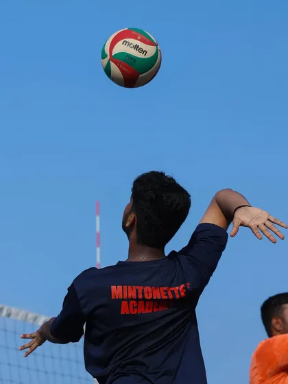 A player practices their serving form, tossing the ball to the perfect height before contact. This fundamental step is key to developing a powerful and accurate serve.