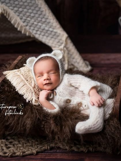 Another angle of the sleeping bear cub, capturing a sweet smile in his sleep.