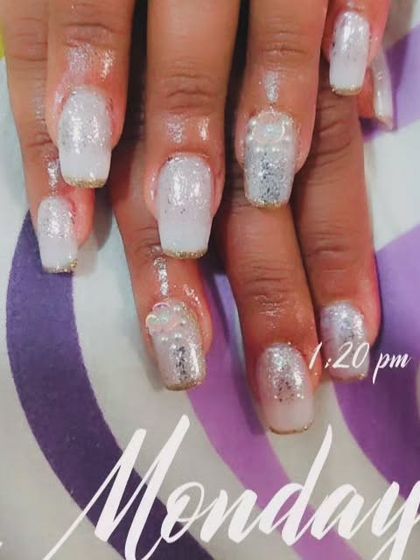 A full set of white glitter nail extensions with a hint of gold at the tips for a frosty, sparkling look.