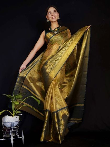 This stunning tissue silk saree in gold and black is pre-stitched for a perfect drape every time. Its metallic sheen makes it an excellent choice for evening parties and festive events.