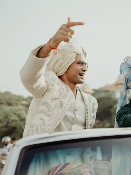 The groom arriving in style in a vintage car for his baraat.