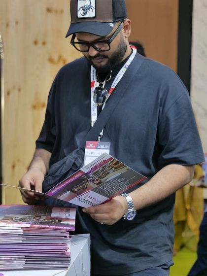A visitor carefully looking through our product brochure at the exhibition. We provide detailed information to help our clients make the right choice.