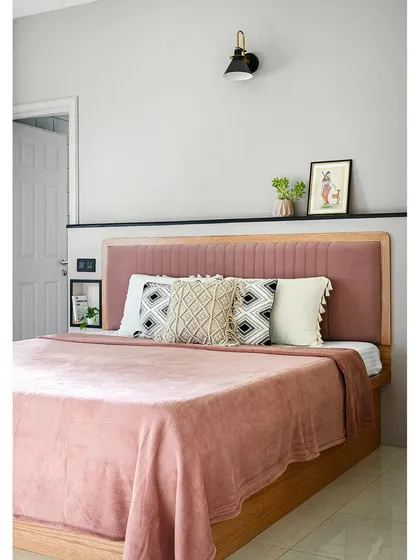 A departure from my usual earthy palette, this parents' room features soft pastels. The blush pink upholstered headboard is set against a mauve wall, and a built-in ledge with niches provides smart bedside storage.
