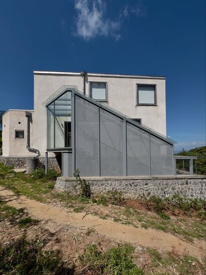 The glass and perforated metal addition to the 'Wildgrass' home. This structure acts as a lantern, bringing in soft, filtered light while maintaining a visual connection to the landscape.