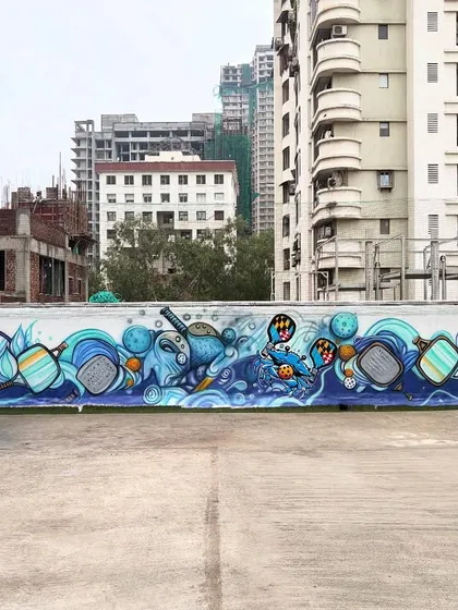 This is a massive graffiti mural I painted for a pickleball court. The entire wall is filled with dynamic, abstract shapes and characters related to the sport.