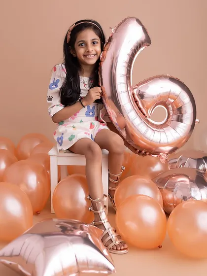 A classic birthday portrait with a giant number balloon. This little girl's smile says it all, a perfect memory of turning six.