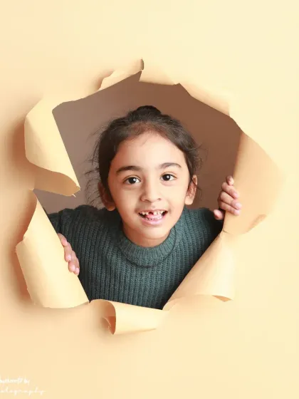 A sweet, gap-toothed smile. The paper-tear concept is perfect for capturing these fleeting childhood details.