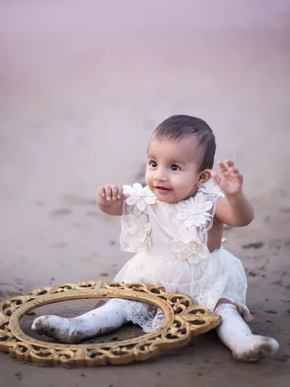 A vintage-inspired moment on the sand. The antique frame adds a touch of whimsy to this sitter session on the beach.
