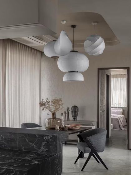 A cluster of sculptural pendant lights hangs over the dining area, acting as a functional art piece that defines the space.