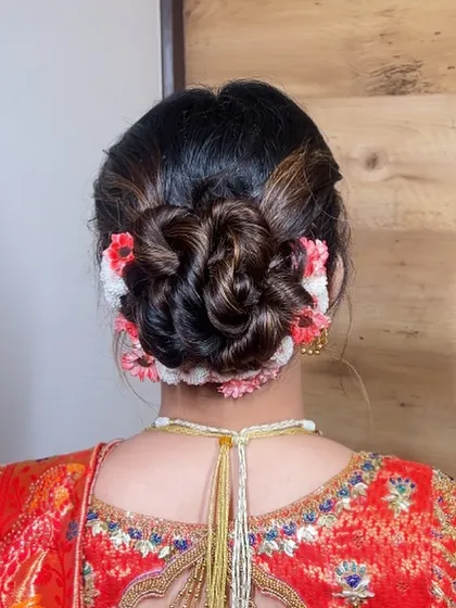 A beautifully woven floral bun using a mix of fresh flowers. This style adds a touch of natural elegance and is perfect for a daytime wedding or traditional ceremony.