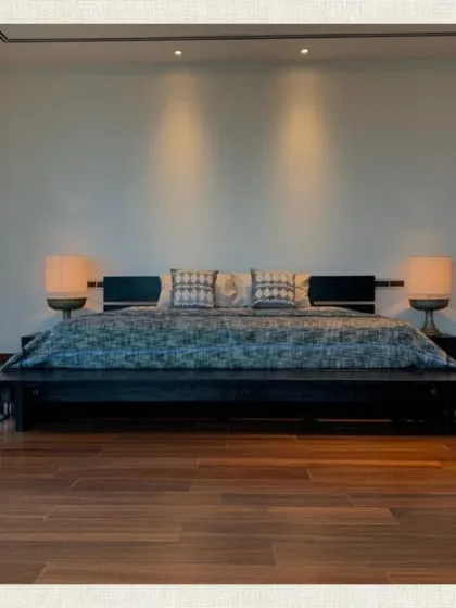 The symmetrical design of this bedroom, with matching bedside lamps and a low platform bed, creates a sense of balance and tranquility.