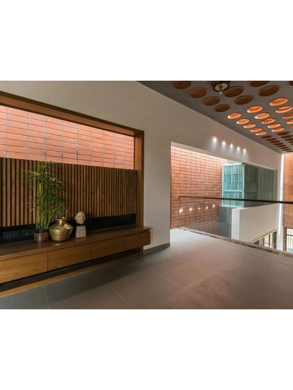 This hallway in 'An Earthy Affair' features a built-in wooden console and a perforated brick screen, or *jaali*, which allows for ventilation and beautiful light play.
