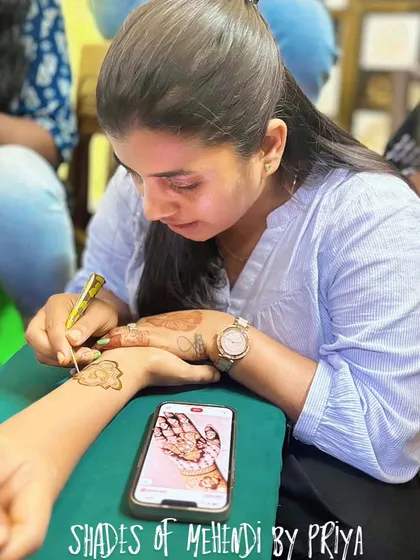 This is me in my element, completely focused on my art. I often use a reference photo on my phone to make sure every detail of a custom design is drawn to perfection for my client.