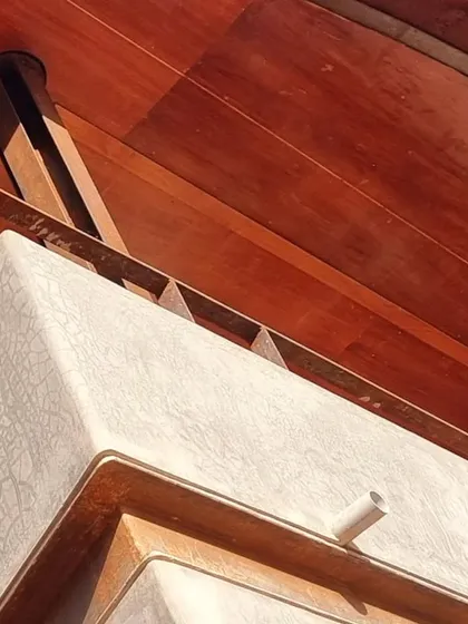 A close-up of 'the hat', the expressive roof of the Soma house. This detail shows the junction of different materials: the textured plaster, the steel edge, and the warm wood ceiling, each celebrated for its unique character.