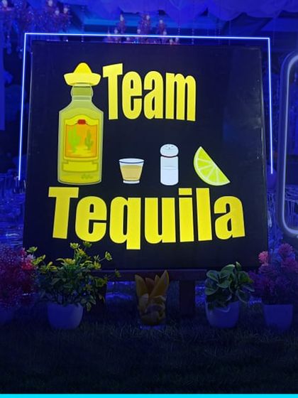 Another look at our popular "Team Tequila" sign, set against a backdrop of lush greenery for an outdoor event. We ensure our setups look great in any environment.