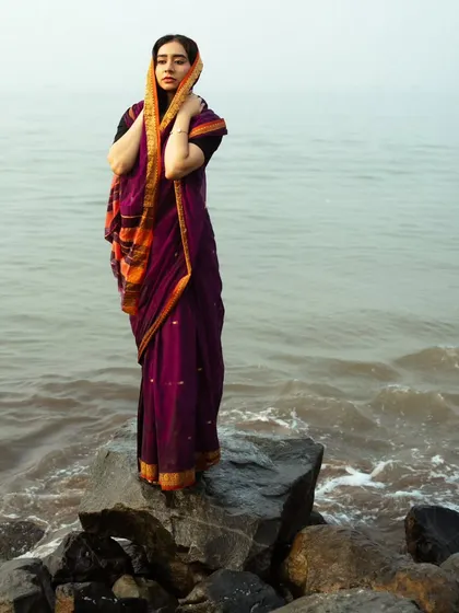 A full-body shot that captures the elegance of the saree and the contemplative mood of the scene.