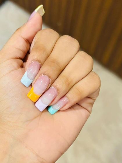 A fun and summery take on the French manicure, with each nail featuring a different pastel-colored tip on a square-shaped extension.