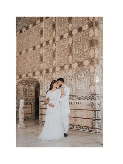 A beautiful portrait set against the intricate mirror work (Sheesh Mahal) inside Amer Fort, showcasing the stunning details of the location.