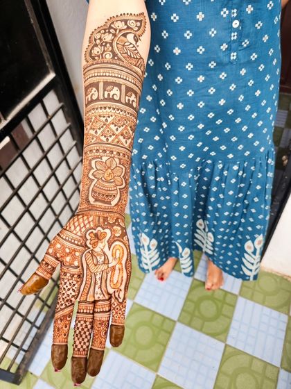 A complete look at this narrative bridal henna, telling a story from the palms to the elbows.