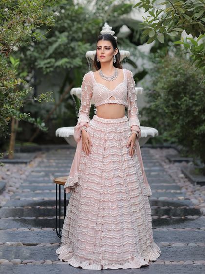 This bride defines modern elegance. The makeup is kept fresh and luminous to complement her intricate pastel outfit and diamond jewelry.