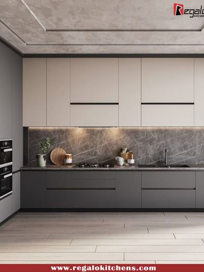 This two-tone L-shaped kitchen combines dark grey base cabinets with off-white upper cabinets for a contemporary look. The marble-patterned backsplash and integrated appliances complete this stylish and highly functional cooking space.