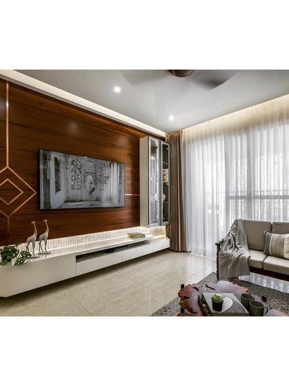 A full view of the living and media area, showcasing the clean lines and warm materials that define this contemporary apartment interior.