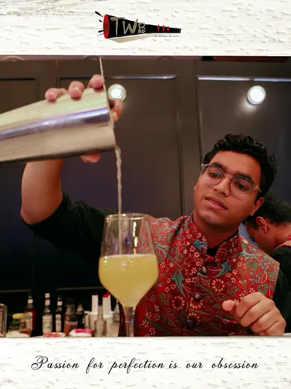 A bartender at a Sangeet night, expertly crafting a cocktail with a smile. Our team brings both skill and positive energy to every event.
