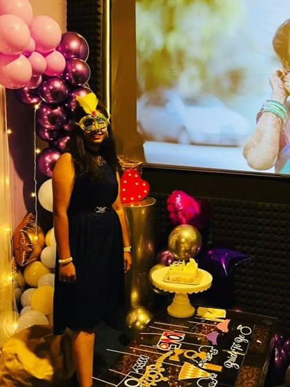 The complete setup for a bride-to-be celebration, with a personalized photo on the screen, a decorated cake table, and plenty of fun props for the guests.