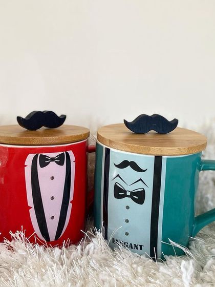 A perfect gift for the dapper gentleman in your life. Our "Elegant Man" mugs come in red and teal, each featuring a tuxedo design and a wooden lid with a fun mustache handle.