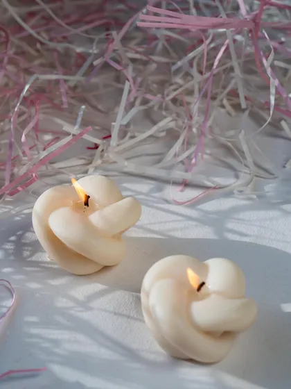 Our knot candles, lit and casting a gentle glow. Say goodbye to boring candles with our unique, structural designs.