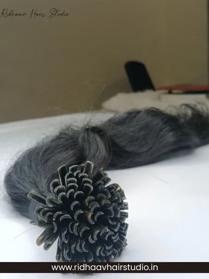 A close-up of our U-Tip wavy hair extensions, showcasing the keratin tips ready for heat-bonded application.