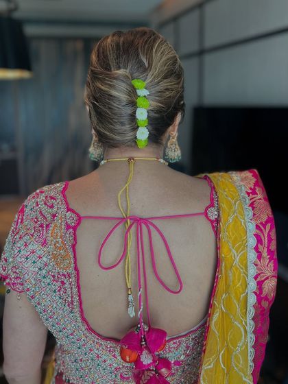 A back view of the French twist, showing the neat lines and the playful pop of color from the flowers.