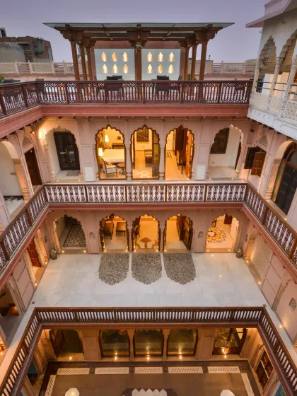 The visually integrated design of Haveli Dharampura, where the central courtyard connects all levels. The terrace above the restaurant is perfectly suited for performances, with laser-cut floor patterns that mimic the shadows of the arches.