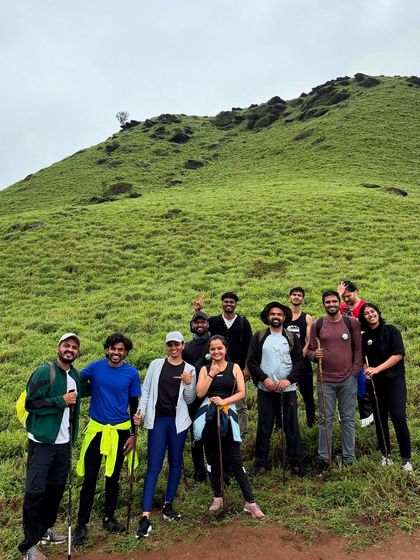 A small group of friends posing on the green slopes of the Bandaje trail.