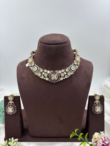 A close-up look at the fine detailing on this Moissanite and Kundan choker. The combination of large uncut stones with a ruby and emerald green center makes it a classic and highly sought-after design.