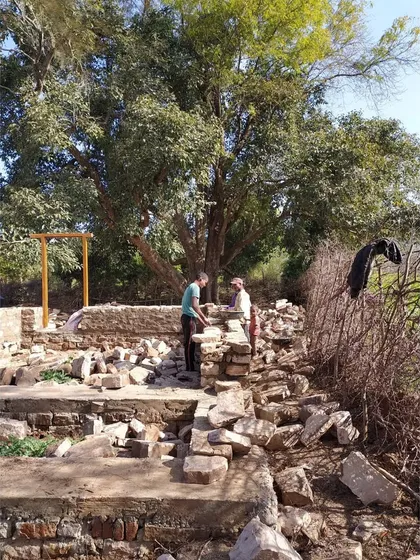 The initial stages of construction for an MP Homestay, using salvaged stones from the site for the foundation. This practice of adaptive reuse minimizes waste and cost, grounding the new structure in the history of the land.