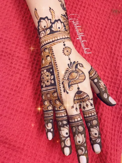 A simple yet elegant design for Karwachauth, featuring a peacock and jhumka motif on the hand.