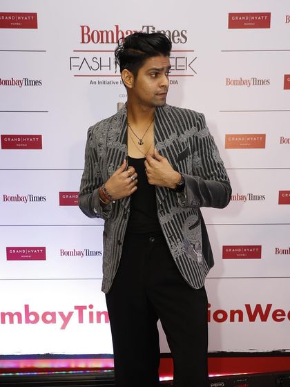 Vinay Mishra on the red carpet, showcasing the elegance of the grey velvet coat. The intricate hand embroidery adds a layer of artistry to the classic silhouette.